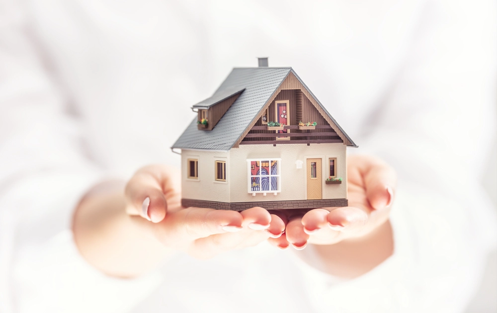 Casa pequeña sujetada entre manos Qué es el domicilio Fiscal - Basal Capital